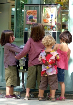 The attraction for all things that can be put into and come out of vending machines starts at an early age!  This photo of young children gathered around a group of vending machines in Paris' jardin du Luxembourg was taken by a Dutch photographer. 